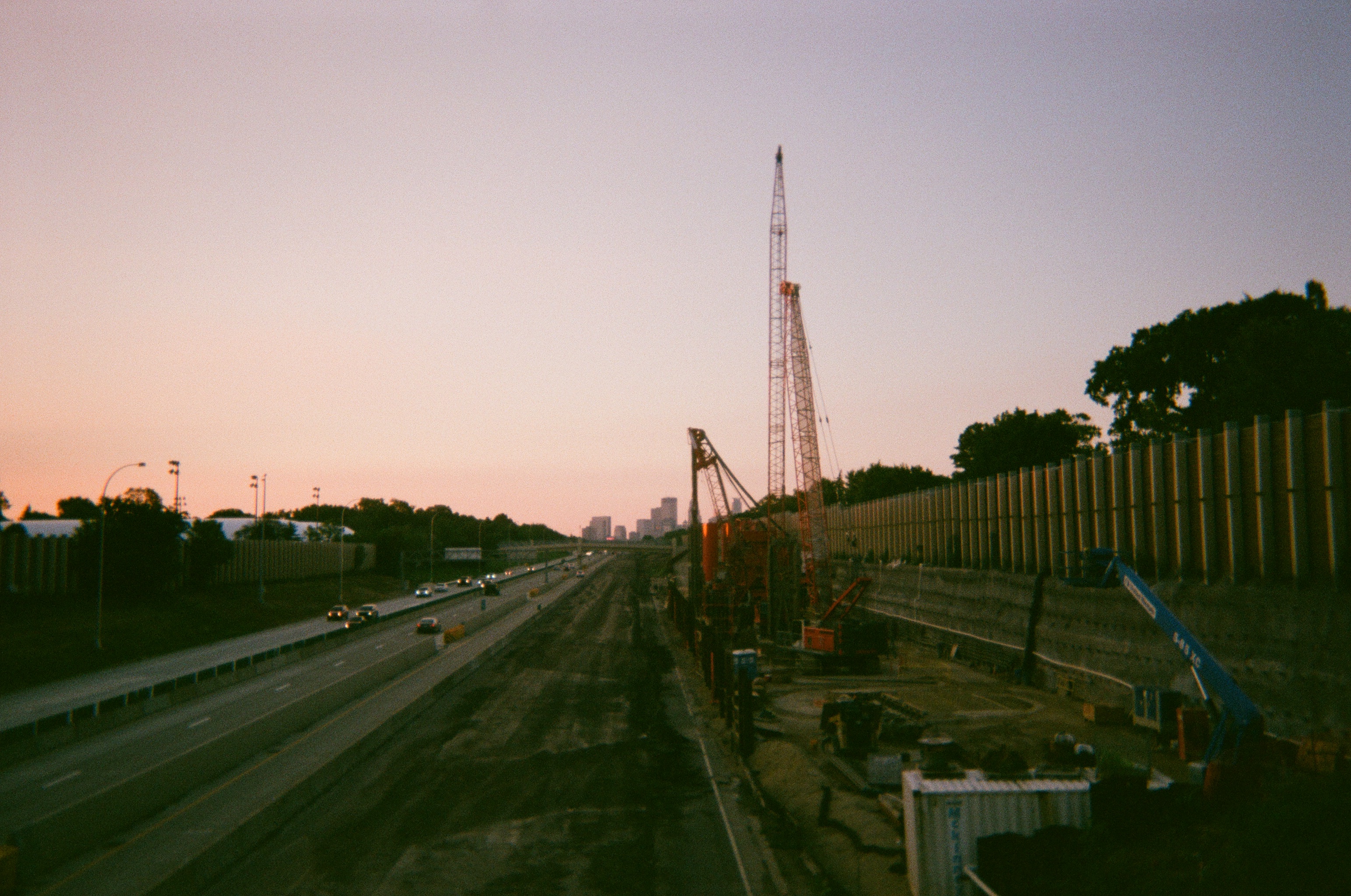 view of highway construction with city skyline visible